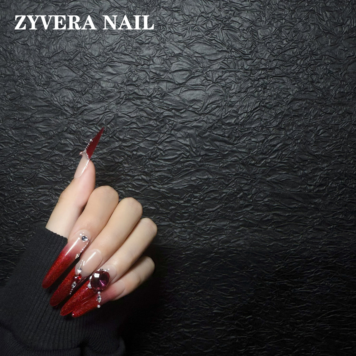 ruby red ombre crystal almond press-on nails worn on hand